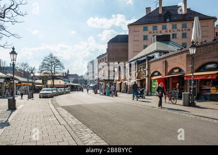 Baviera-Monaco-Germania, 20. März 2020: Poche persone camminano su Viktualienmarkt, a Monaco, che è di solito affollata, ma rimane vuota a causa del nuovo coron Foto Stock