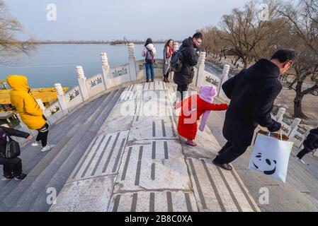 Turisti sul ponte della cintura di giada su un lago Kunming nel Palazzo d'Estate, ex giardino imperiale a Pechino, Cina Foto Stock