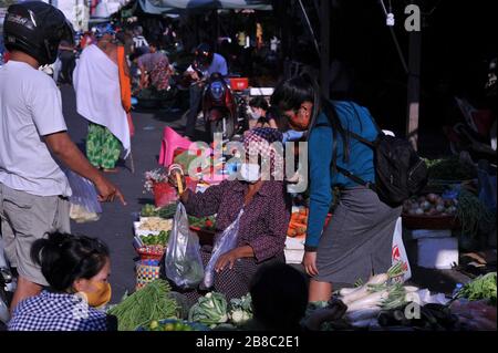 Venditore di verdure cambogiane che indossa una maschera e utilizza una scala per le mani durante la pandemia di coronavirus. Il mercato russo, Phnom Penh, Cambogia. © Kraig Lieb Foto Stock