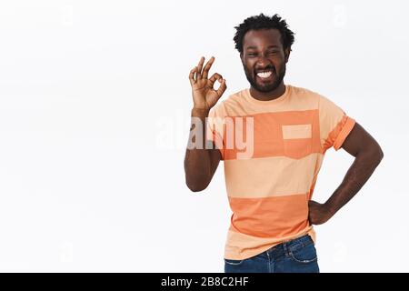Ragazzo non avendo problemi a riparare qualcosa se stesso. Felice e allegro giovane bell'amico afro-americano ha aiutato la ragazza mostrando okay, ok o. Foto Stock