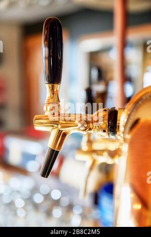 Rubinetto di birra Golden cromo o rubinetto in un bar o pub. Vista ravvicinata. Foto Stock