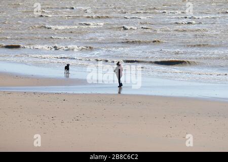 Campanatura, East Sussex, Regno Unito. 21 Mar 2020. UK Weather: Condizioni molto breezy giù al Camber Sands con la marea che va alcune persone a piedi lungo la spiaggia deserta. ©Paul Lawrenson 2020, Photo Credit: Paul Lawrenson/Alamy Live News Foto Stock