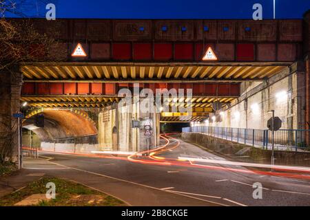 Sentieri leggeri da veicoli sotto la Vyne Road / Chapel Hill ponte ferroviario E1/135A sulla linea ferroviaria BML1 a Basingstoke di notte. REGNO UNITO Foto Stock