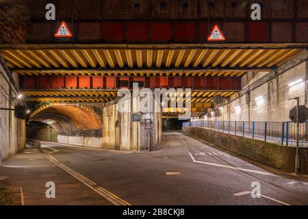 Vyne Road / Chapel Hill ponte ferroviario E1/135A sulla linea ferroviaria BML1 a Basingstoke di notte. RBE costruzione di travi in acciaio e archi in mattoni. Foto Stock