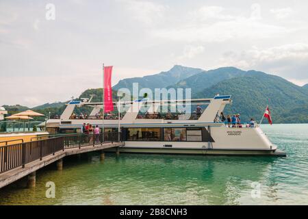 St.Gilgen, Austria - 27 luglio 2019: Persone a bordo della barca 'Wolfgang Amadeus' al molo nella città alpina sul lago Wolfgangsee. Foto Stock