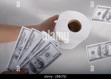 Primo piano sell-buy tissue, maniglie carta igienica tissue e denaro di 100 dollari US banconota un sacco di Foto Stock