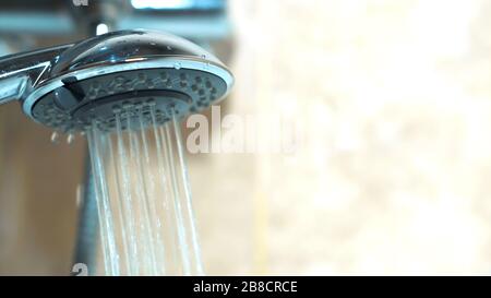 Primo piano - l'alto dell'idraulico delle mani dei guanti controlla il lavoro della doccia. Ha installato un nuovo rubinetto d'acqua nel bagno Foto Stock