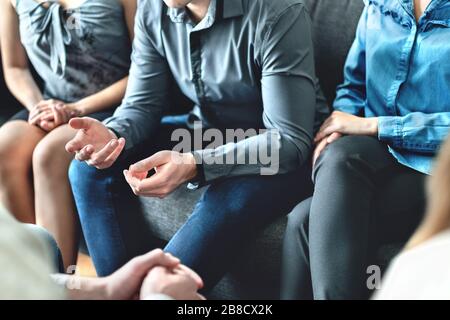 Consulenza e conversazione in terapia di gruppo o riunione. Uomo che condivide la storia con la comunità. Gente di affari casuale in discussione. Supporto dei pari, fiducia. Foto Stock