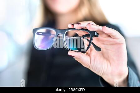 Ottico, ottometristo, oculista o medico oculista tenere occhiali e specifiche con nuove lenti. Specialista professionale della vista in clinica o in negozio. Foto Stock