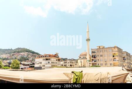 Vista sulla città vecchia di Alanya, Turchia, con tenda in un mercato all'aperto, minareto, moschea ed edifici locali. Cultura turca tradizionale e islam. Foto Stock