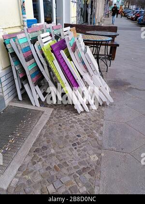 Sedie e tavoli da giardino ripiegati da un ristorante di strada nel quartiere Friedrichshain di Berlino durante la chiusura di coronavirus in Germania. Foto Stock