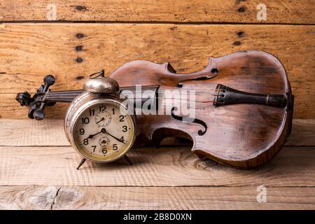 Orologio antico e vecchio violino su tavolo in legno d'epoca - fuoco selettivo, spazio copia Foto Stock