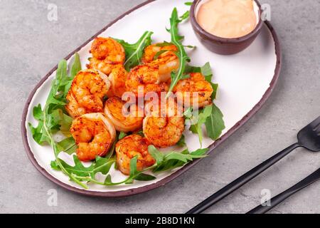 Antipasto caldo gamberi fritti re, rucola, salsa Foto Stock