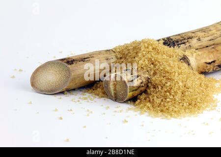 Canna da zucchero e mucchio di zucchero, bruciatura di canna da zucchero, pezzo di canna e zucchero granulato di canna da zucchero su sfondo bianco Foto Stock