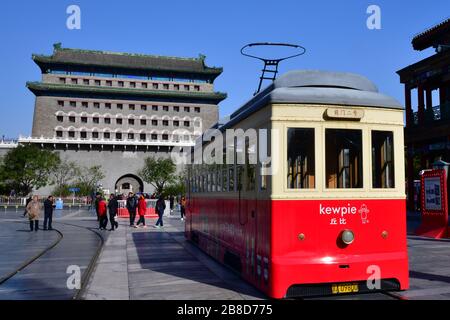 Pechino, Cina-Ottobre 2019; vista sulla Gate House o Zhengyangmen con in prima linea il colorato tram storico in Qianmen Street, un famoso ped Foto Stock