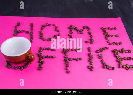 Home Office fatto di chicchi di caffè disposti su uno sfondo rosa Foto Stock