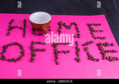 Home Office fatto di chicchi di caffè disposti su uno sfondo rosa Foto Stock