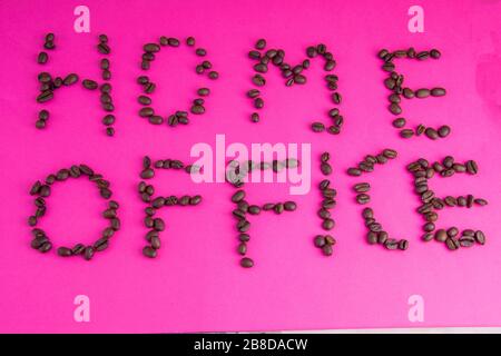 Home Office fatto di chicchi di caffè disposti su uno sfondo rosa Foto Stock