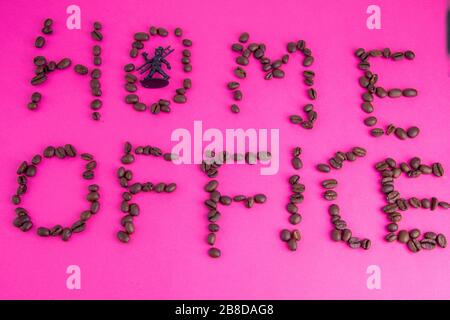 Home Office fatto di chicchi di caffè disposti su uno sfondo rosa Foto Stock