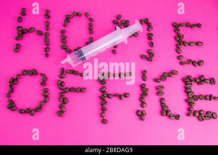 Home Office fatto di chicchi di caffè disposti su uno sfondo rosa Foto Stock