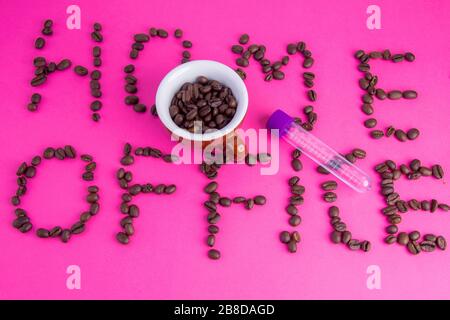 Home Office fatto di chicchi di caffè disposti su uno sfondo rosa Foto Stock