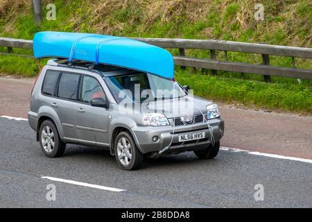 2006 argento Nissan X-Trail Columbia DCI auto che trasportano l'attrezzatura per il tempo libero composto da kayak e canoe sul tetto in viaggio sulla M6. REGNO UNITO Foto Stock