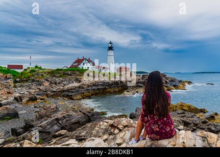 Donna ipnotizzante la vista del faro di Portland Head a Portland Maine USA Foto Stock