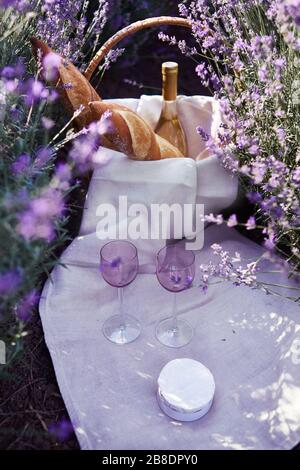 due bicchieri e vino con cesto di vimini nella lavanda Foto Stock