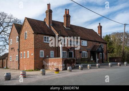 Il pub inglese è chiuso a causa della pandemia di coronavirus del covid-19, con barili di birra allineati di fronte. The Plow Inn, villaggio di Little London, Hampshire, Regno Unito Foto Stock