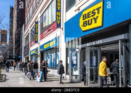 New York, Stati Uniti. 21 Mar 2020. La gente tiene un certo distanziamento sociale mentre attendono in linea fuori di un deposito a New York City, la città chiuderà tutte le attività non essenziali dopo un blocco di stato e nuove restrizioni che entreranno in vigore la domenica per mitigare la diffusione della pandemia del coronavirus. Credit: Enrique Shore/Alamy Live News Foto Stock