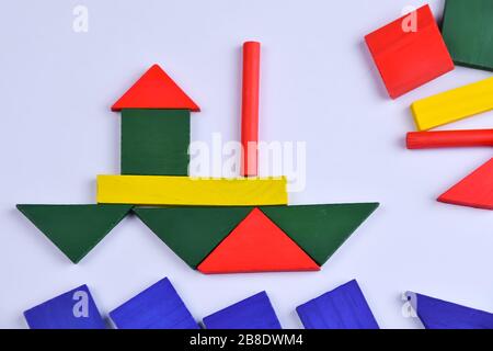 Una barca da parti in legno multicolore di un costruttore per bambini su sfondo bianco Foto Stock