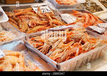 Mucchio di gamberetti e langoustine in mostra sul mercato del pesce Foto Stock