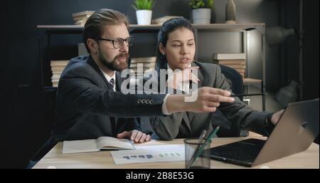 Colleghi che discutono del lavoro sul notebook Foto Stock