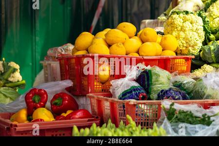 frutta fresca e colorata e verdure da un mercato di strada del sud-est asiatico. limoni gialli e paprika rossa in vendita Foto Stock