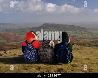 I bambini ammirano la vista dello Skirrid - Ysgyd Fawr - dalla cima del Sugarloaf - Y Fâl, vicino Abergavenny, Galles, Regno Unito Foto Stock