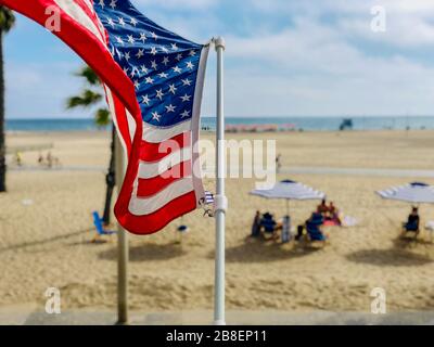 Bandiera americana con la spiaggia sullo sfondo a Santa Monica Beach, California, USA. Foto Stock