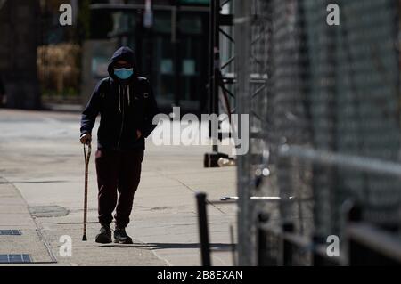 Boston, Massachusetts, Stati Uniti. 21 Mar 2020. Il virus Corona, COVID-19, ha causato un cambiamento di vita in Massachusetts. Ciò include la chiusura della maggior parte delle aziende e la richiesta di autoquarantena. Un uomo cammina lungo la strada in una maschera. Credito: Allison Dinner/ZUMA Wire/Alamy Live News Foto Stock