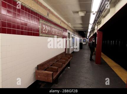 New York, New York, Stati Uniti. 21 Mar 2020. Un passeggero solone che indossa una maschera attende il treno numero 1 alla 23rd Street station nel quartiere Chelsea di Manhattan il sabato sera, 21 marzo 2020. New Yorker's da e grande attenzione avvertimento di rimanere a casa alla luce della pandemia di coronavirus. Credit: Adam Stoltman/Alamy Live News Foto Stock