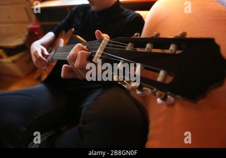 Kaufbeuren, Germania. 21 Mar 2020. Un uomo suona una chitarra nel salotto di casa sua. (A dpa-KORR: 'Lagerkoller o una possibilità? Come (sopravvivere) in isolamento' dal 22.03.2020). Credit: Karl-Josef Hildenbrand/dpa/Alamy Live News Foto Stock