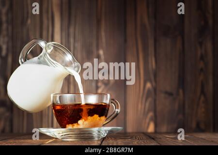 caraffa volante che versa il latte nella tazza Foto Stock