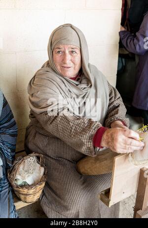 Una donna anziana che lavora su pizzi fatti a mano o bizzilla nel villaggio di Ghajnsielem a Gozo, Malta Foto Stock