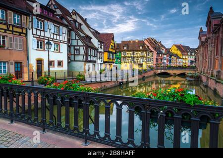 Case colorate in fila sul lungomare con fiorito lungomare, centro città di Colmar, regione Alsazia, Francia, Europa Foto Stock