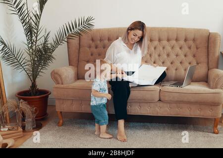 Bella donna d'affari di lavoro a casa. Multi-tasking, freelance e concetto di maternità. Madre di lavoro carriera Foto Stock