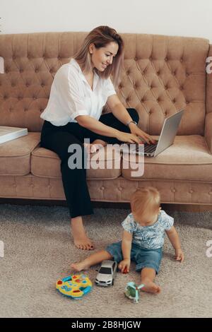 Bella donna d'affari di lavoro a casa. Multi-tasking, freelance e concetto di maternità. Madre di lavoro carriera Foto Stock