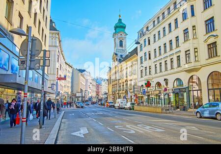 VIENNA, AUSTRIA - 19 FEBBRAIO 2019: La strada trafficata Landstrasser Hauptstrasse con vecchio alloggio e campanile della Chiesa di Santa Elisabetta d'Ungheria, il febbraio Foto Stock