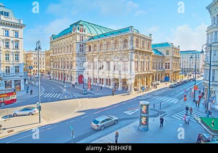 VIENNA, AUSTRIA - 19 FEBBRAIO 2019: La trafficata Albertinaplatz con vista all'angolo dell'Opera di Stato - edificio storico in pietra con sculture ornate e m. Foto Stock