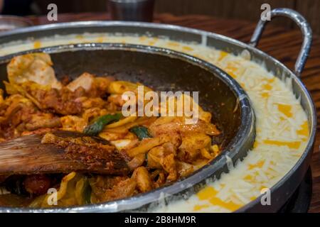 DAK Galbi, pollo fritto piccante coreano con verdure e salsa piccante coreana o Gochujang in grande tegame caldo, con formaggio Foto Stock