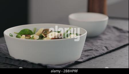 formaggio a pezzi da insalata con pomodori kumato e spinaci in ciotola bianca, foto ampia Foto Stock