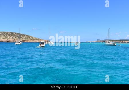 Barche ancorate nelle acque turchesi di Cala Comte, Ibiza, Spagna Foto Stock