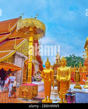 CHIANG mai, THAILANDIA - 7 MAGGIO 2019: L'ombrello cerimoniale di chatra dorato simile a pizzi e belle statue di Buddha d'oro nel cortile di Wat Phra che fanno Foto Stock